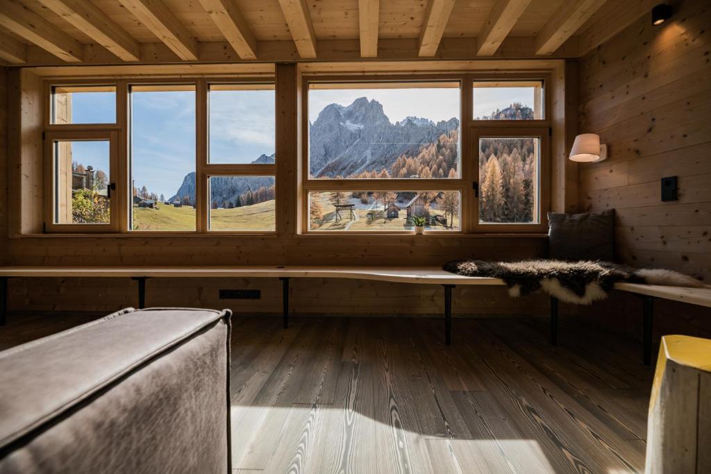 a room with a bench and a large window at Rotwandwiesen Chalets SKI IN/OUT - 1900mt in Sesto