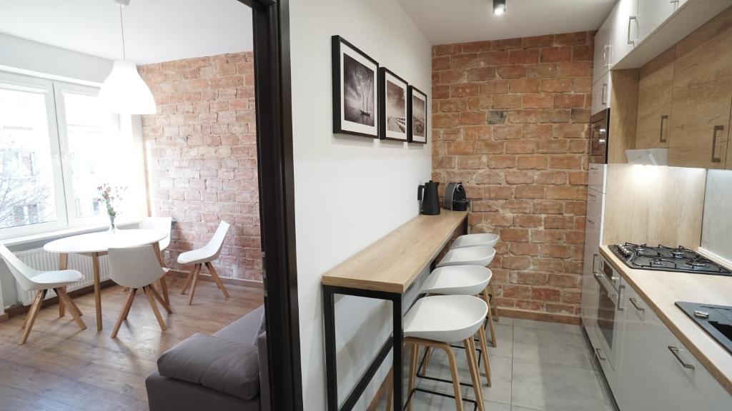 una cucina e una sala da pranzo con parete in mattoni di Apartament Akali a Kielce
