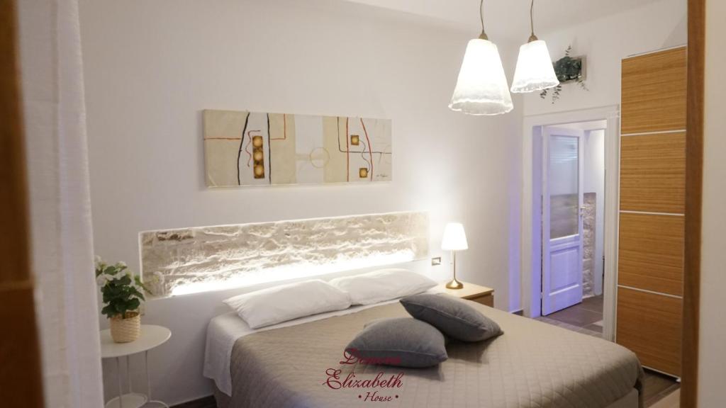 una camera con un letto con due cuscini sopra di Dimora Elizabeth II a Modugno