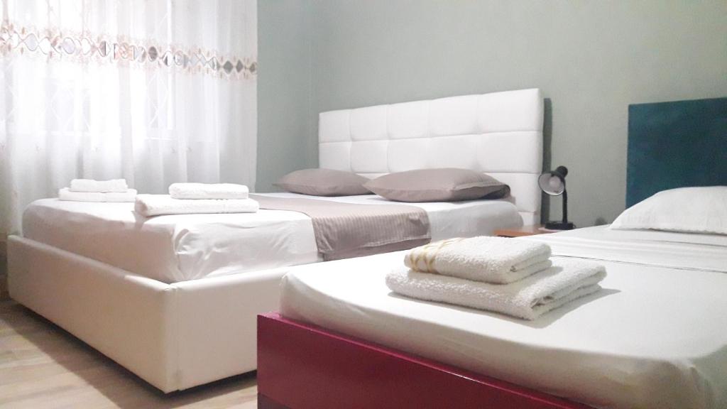 two beds in a room with towels on them at Tirana City Center Apartment in Tirana