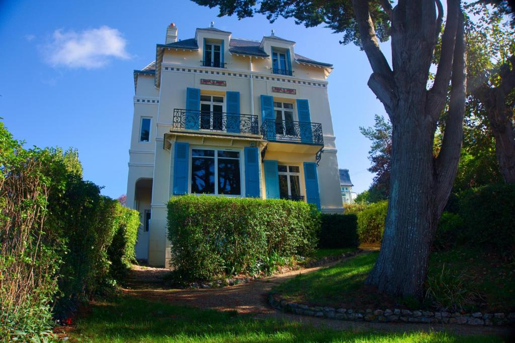 a blue and white house with a tree at Villa Classée 4 étoiles Vue mer exceptionnelle in Trouville-sur-Mer