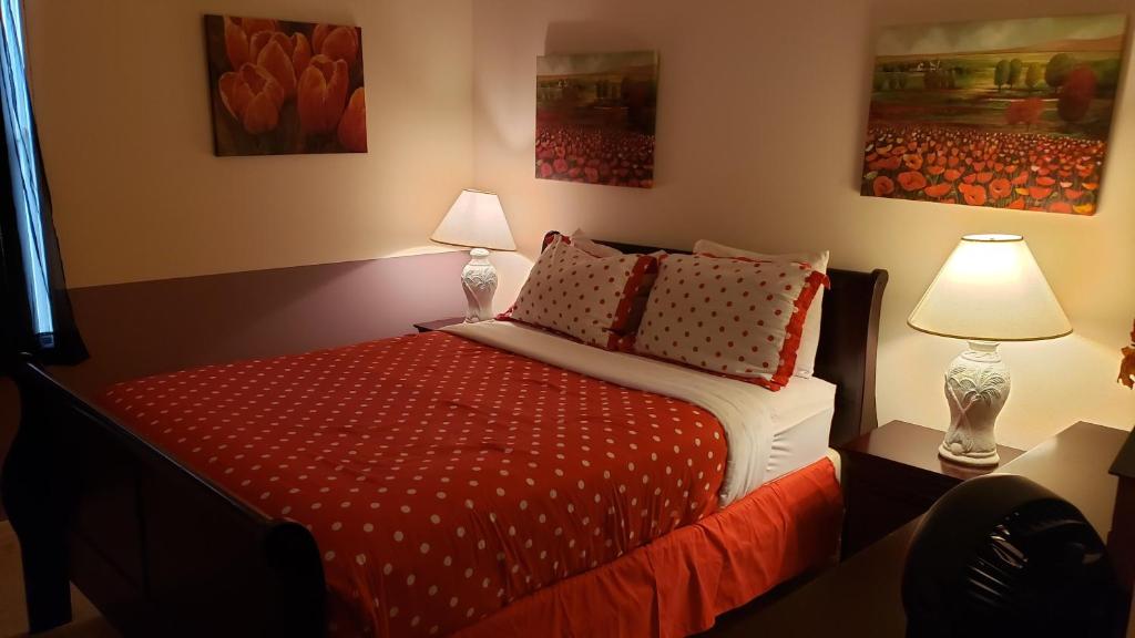 1 dormitorio con 1 cama con sábanas rojas y 2 lámparas en Orlando Discount Villas - Davenport, en Davenport