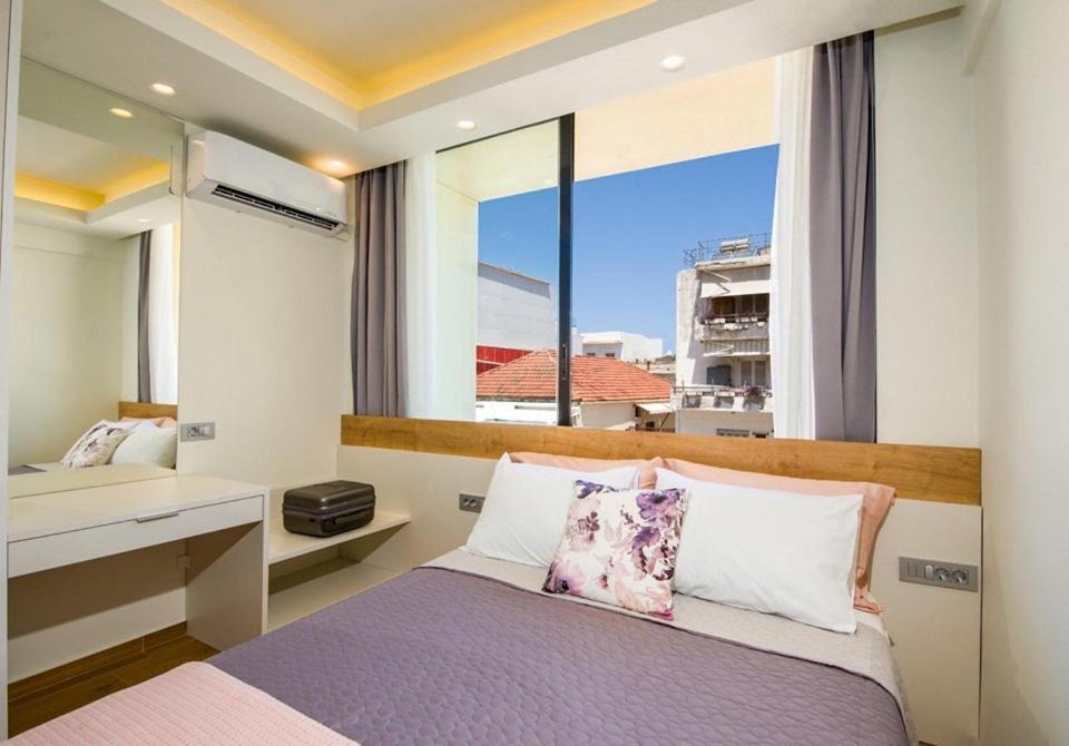 sypialnia z łóżkiem i dużym oknem w obiekcie Tonia's elegant place with Parking w Chanii