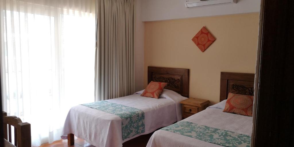 um quarto com 2 camas e uma janela em Estrella de Mar em Puerto Vallarta