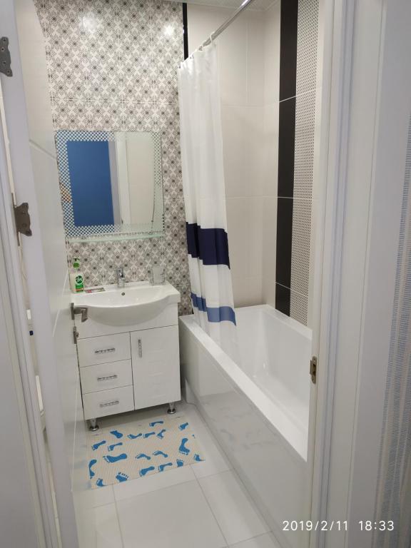 een witte badkamer met een wastafel en een douche bij Стильная квартира для отдыха и бизнес поездок in Kiev