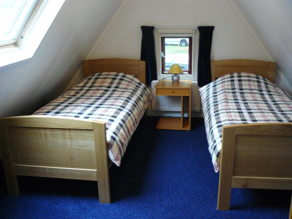 1 Schlafzimmer mit 2 Betten, einem Tisch und einem Fenster in der Unterkunft Bakhuisje in Emst
