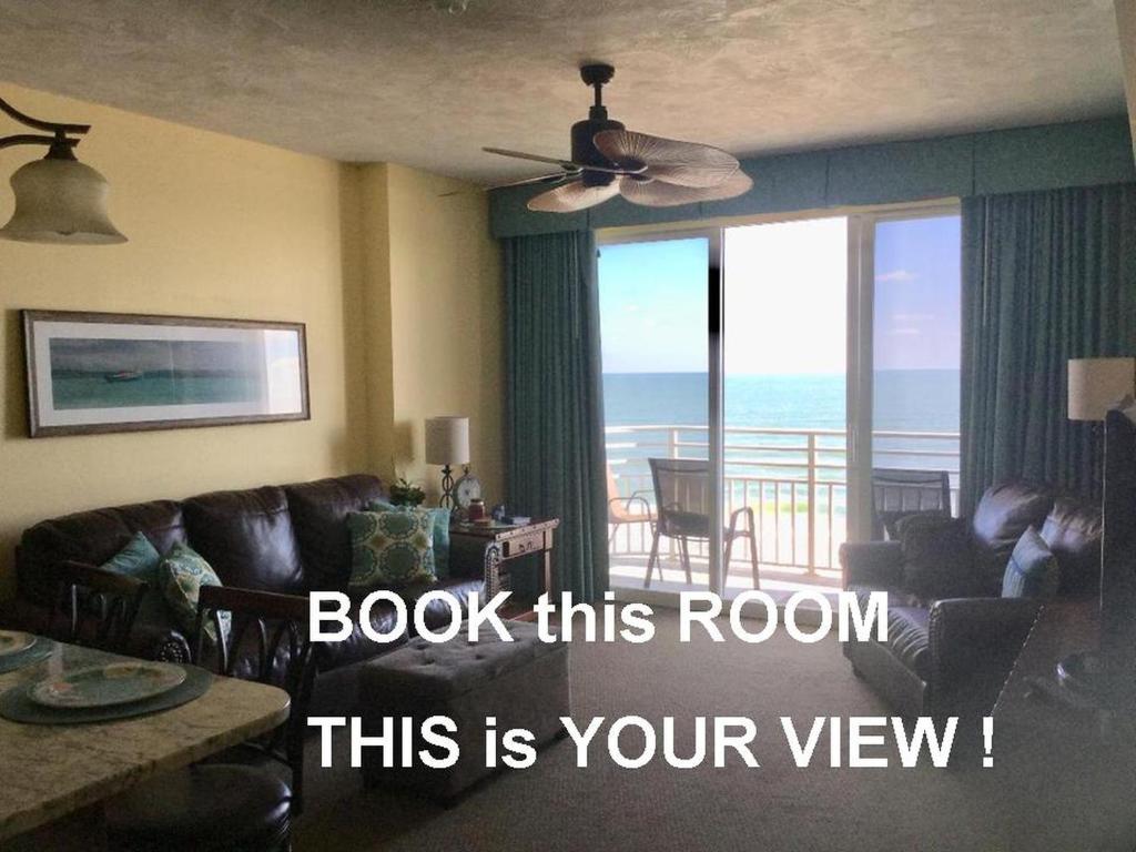 a living room with a couch and a view of the ocean at Ocean Walk Resort - Striking Ocean Front View in Daytona Beach