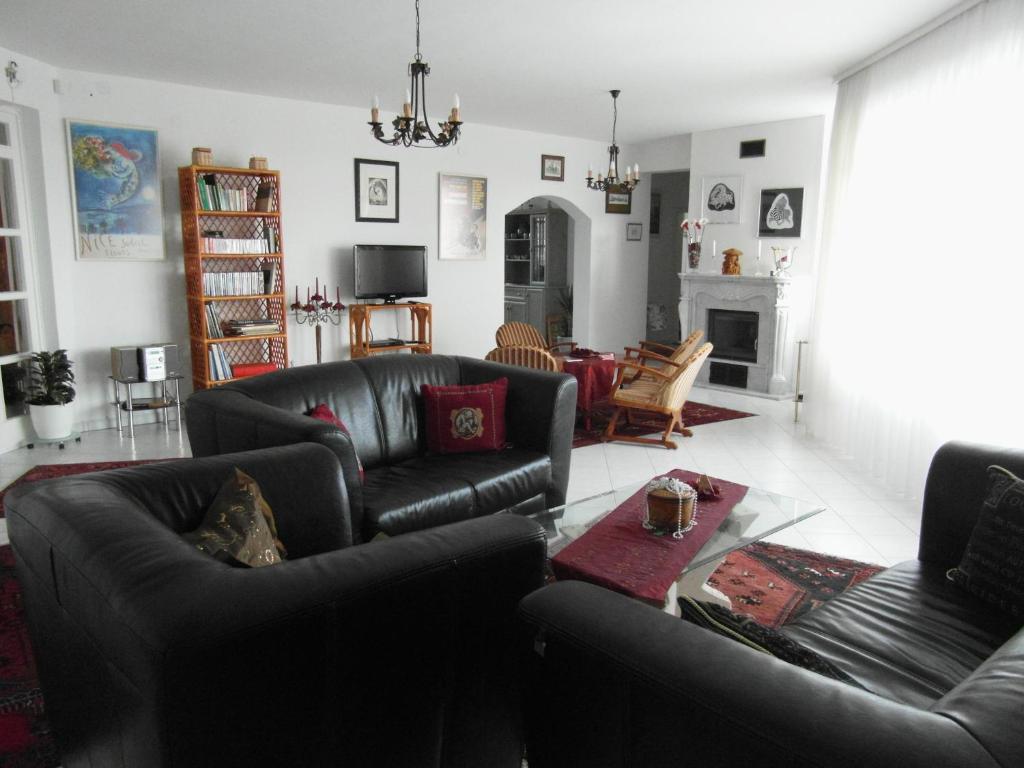 a living room with two leather couches and a fireplace at Lijoli Lounge Vendégház in Alsóörs