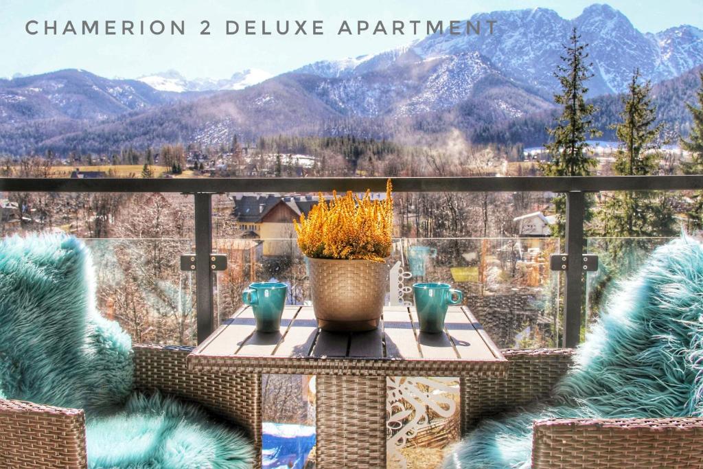 a balcony with a table with a view of mountains at Polana Szymoszkowa Ski Resort - Chamerion Apartments in Zakopane