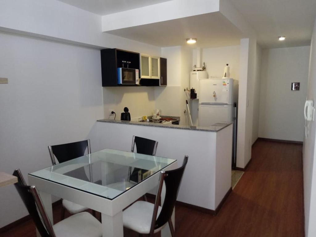 a small kitchen with a table and a refrigerator at San Lorenzo 756 in Rosario