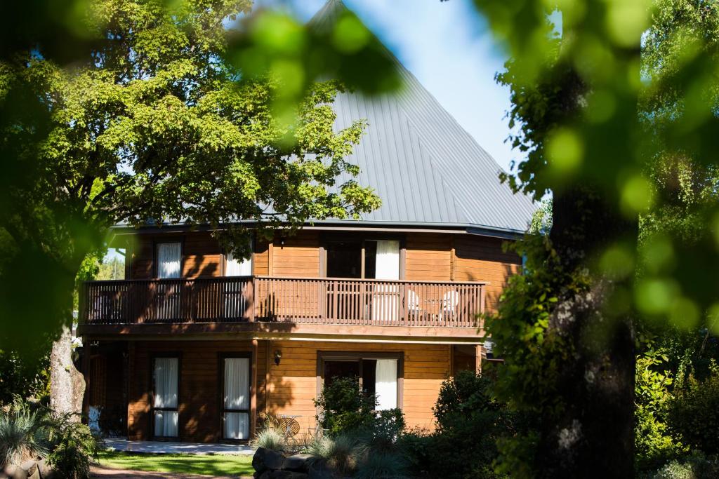 duży brązowy dom z balkonem w obiekcie Alpine Lodge Motel w mieście Hanmer Springs