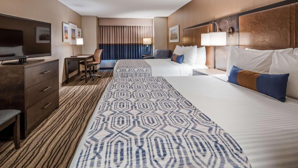 Habitación de hotel con 2 camas y TV de pantalla plana. en Best Western PLUS Calgary Centre Inn en Calgary