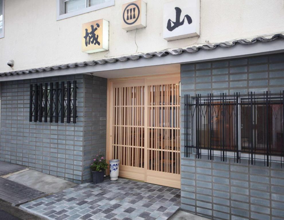 un edificio con una puerta y una señal en él en Shiroyama Ryokan, en Ikuma