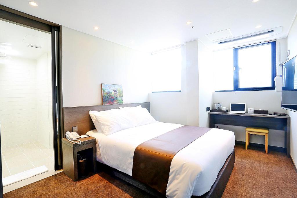 Postel nebo postele na pokoji v ubytování Grandmillions Hotel Seogwipo