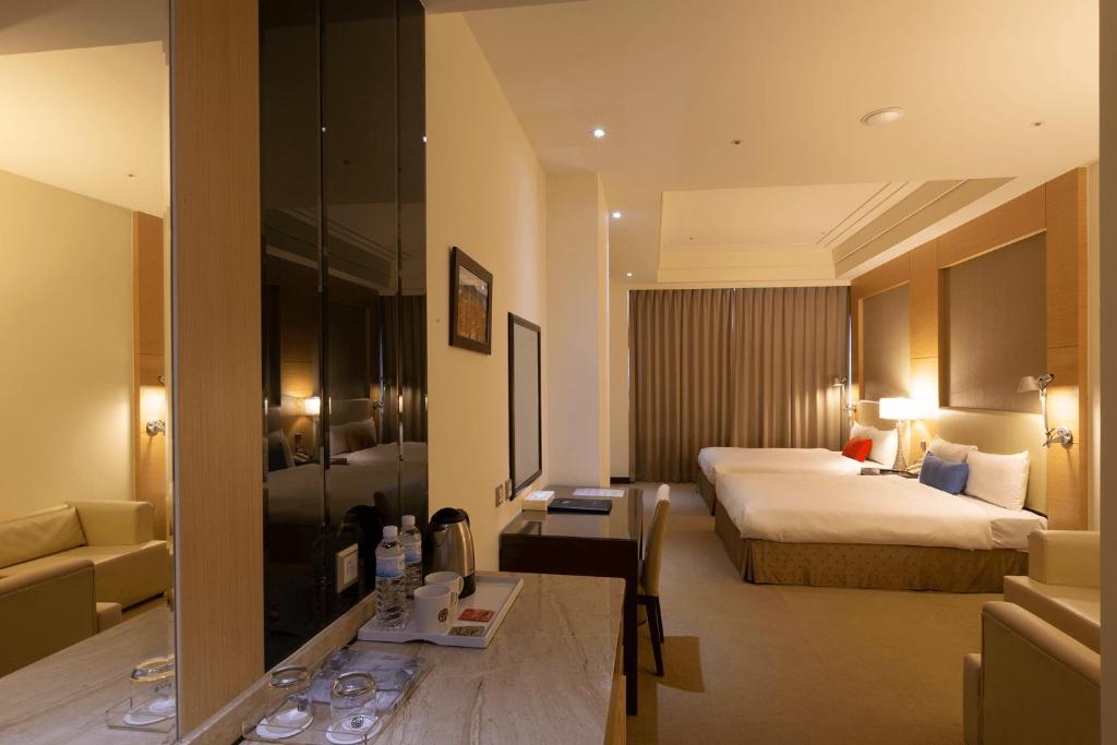 a hotel room with a bed and a desk in a room at Ever Delightful Business Hotel in Chiayi City