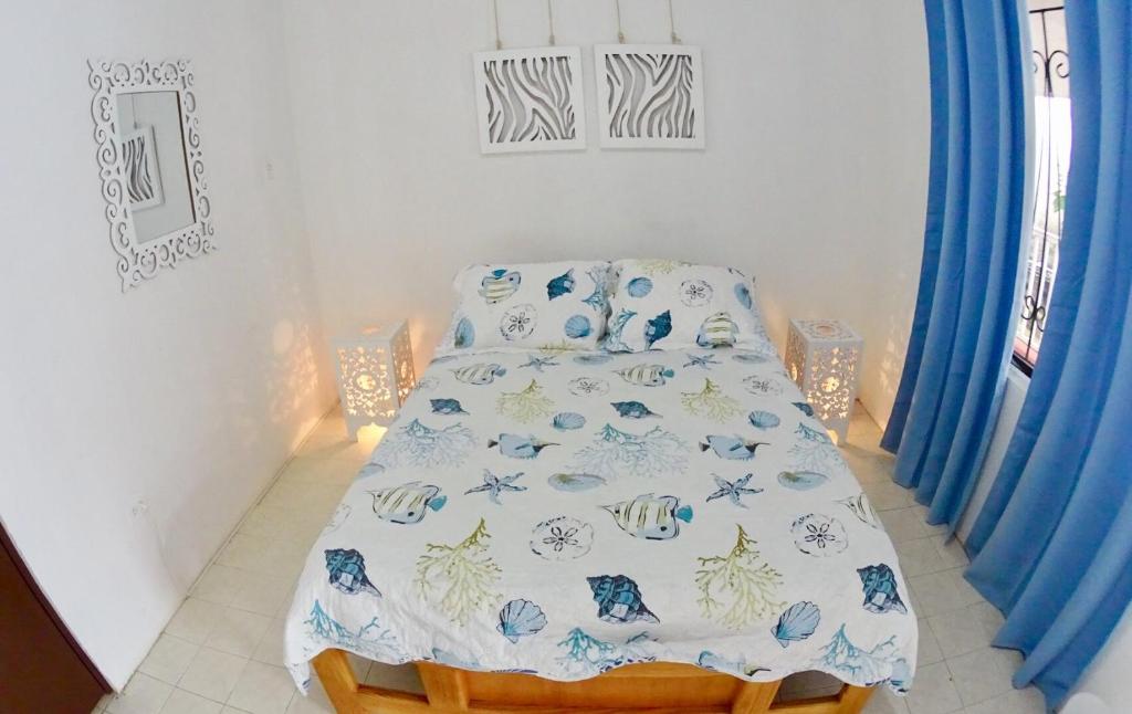 um quarto com uma cama com um cobertor azul e branco em Marmows Place em San Andrés