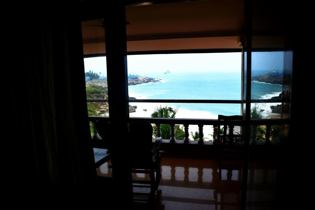 Cette chambre dispose d'une fenêtre donnant sur l'océan. dans l'établissement Vijaya Varma Beach Resort, à Kovalam
