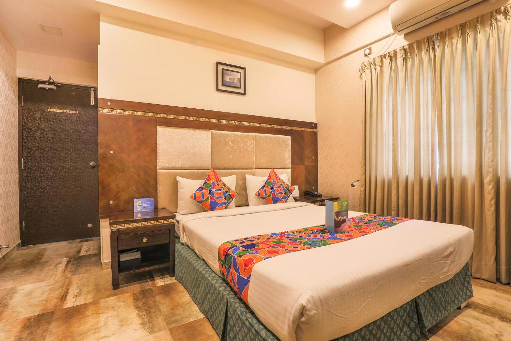 een hotelkamer met een groot bed in een kamer bij FabHotel Frazer Suites Pulikeshi Nagar in Bangalore