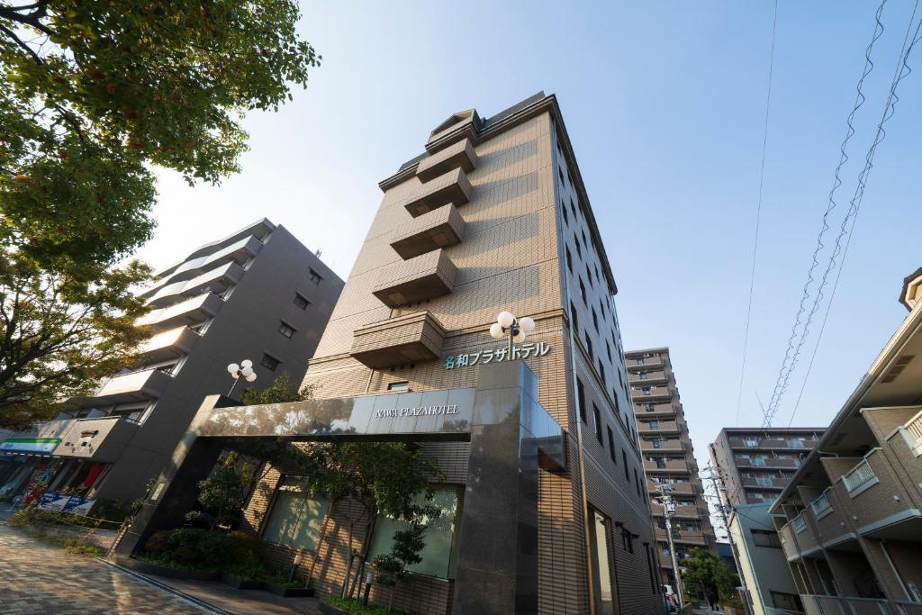 a tall building on a city street with buildings at Nawa Plaza Hotel in Tokai