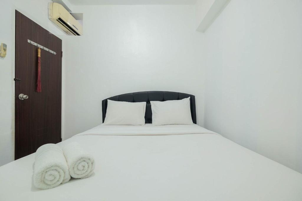 Cama o camas de una habitación en New Furnished 2BR Apartment @ Mutiara Bekasi By Travelio