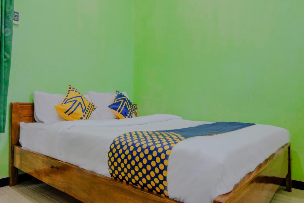諫義里的住宿－Super OYO 1759 Family Residence Syariah，一间卧室配有黄色和蓝色枕头的床