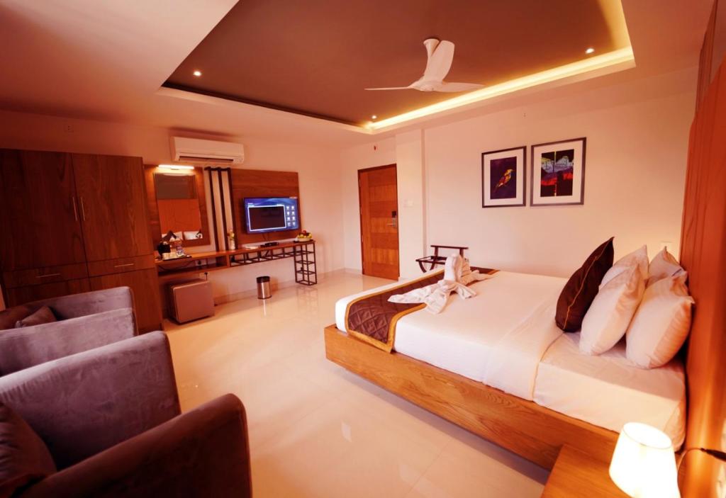 カンヌールにあるWithInn Hotel - Kannur Airportのベッドとテレビ付きのホテルルーム