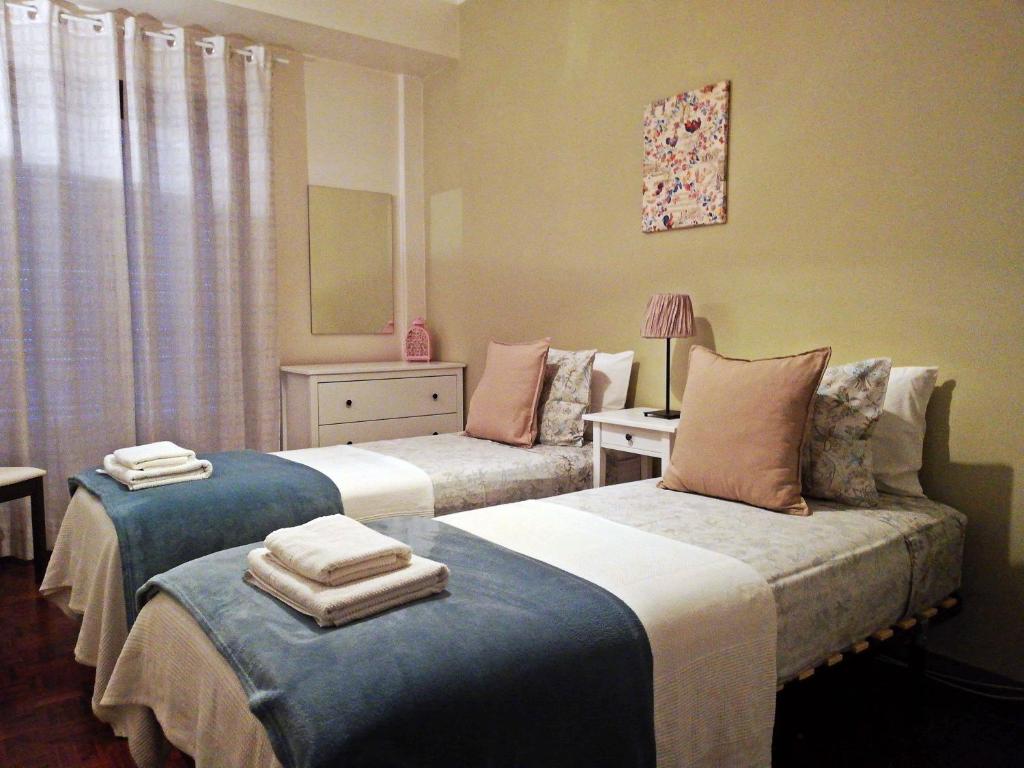 ein Schlafzimmer mit 2 Betten und Handtüchern darauf in der Unterkunft TripGeo Apartment Roma in Lissabon