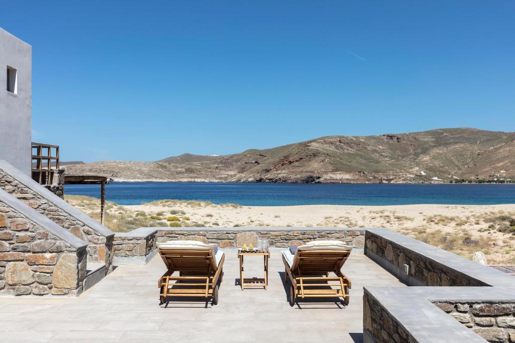 a patio with chairs and a table and a beach at Ammoa Beach Residences in Vayiá