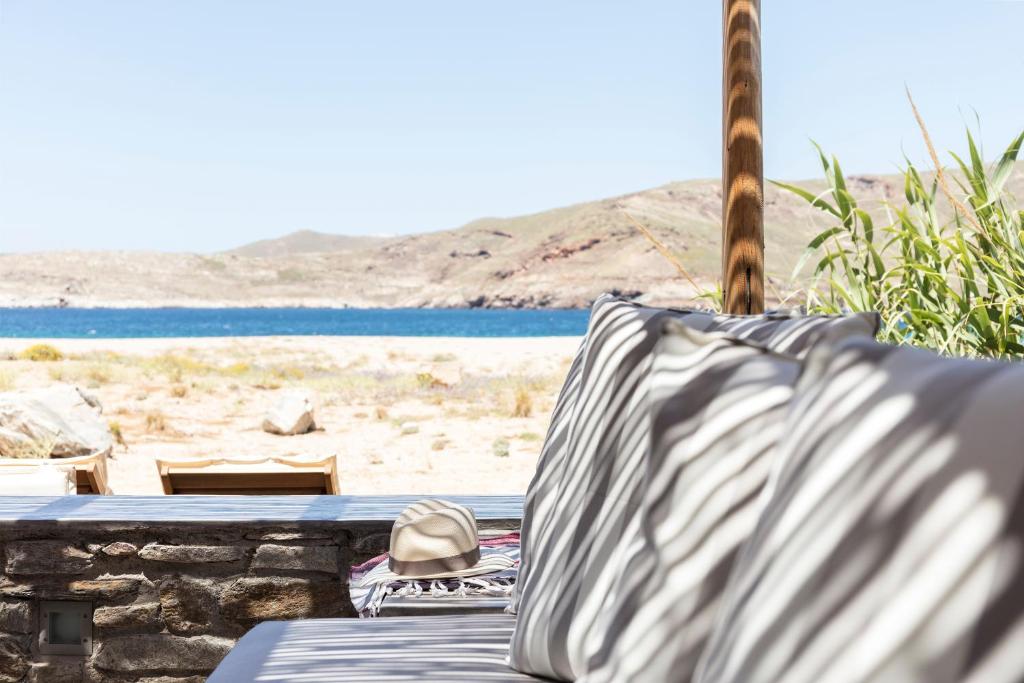 a bed with a hat sitting on a beach at Ammoa Beach Residences in Vayiá