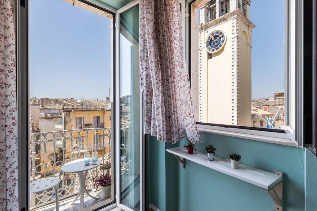 a balcony with a view of a clock tower at St Spyridon Cosy Apartment by Konnect, Old Corfu Town in Corfu Town