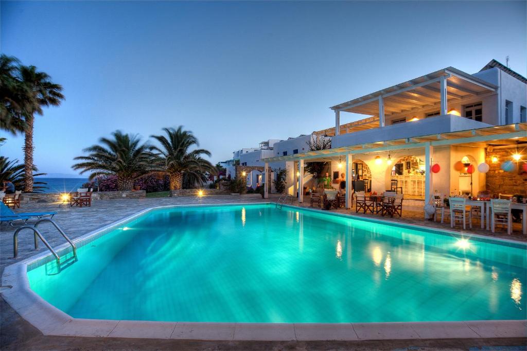 a swimming pool in front of a house at Paros Philoxenia in Chrissi Akti