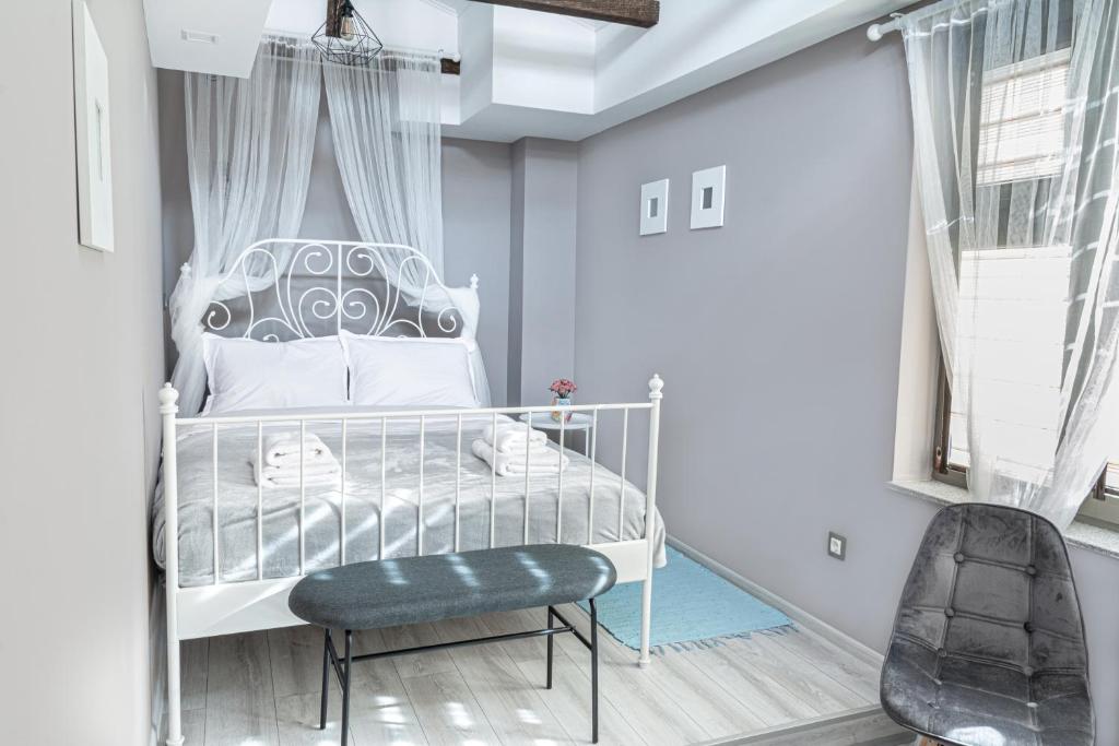 a bedroom with a white bed and a chair at The Red Roof House in Plovdiv