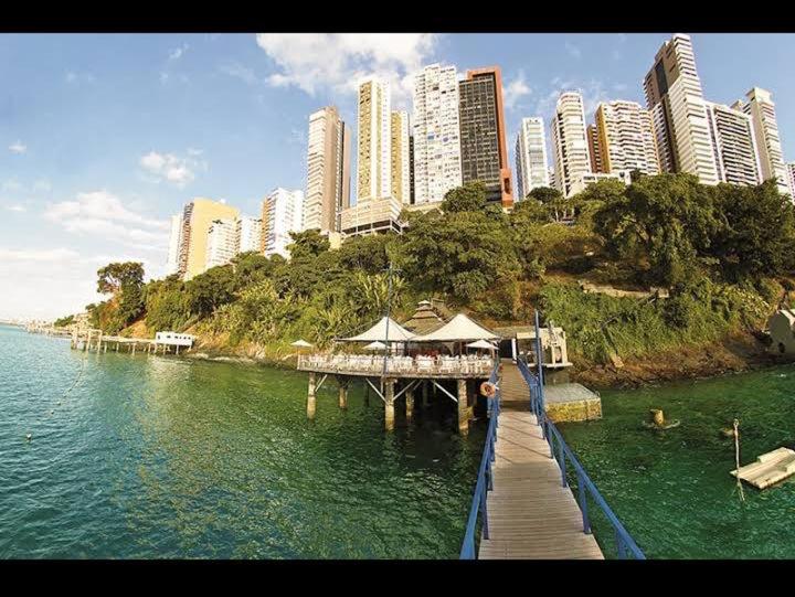 a pier in the water with a city in the background at Sol Victoria Marina Lofts in Salvador
