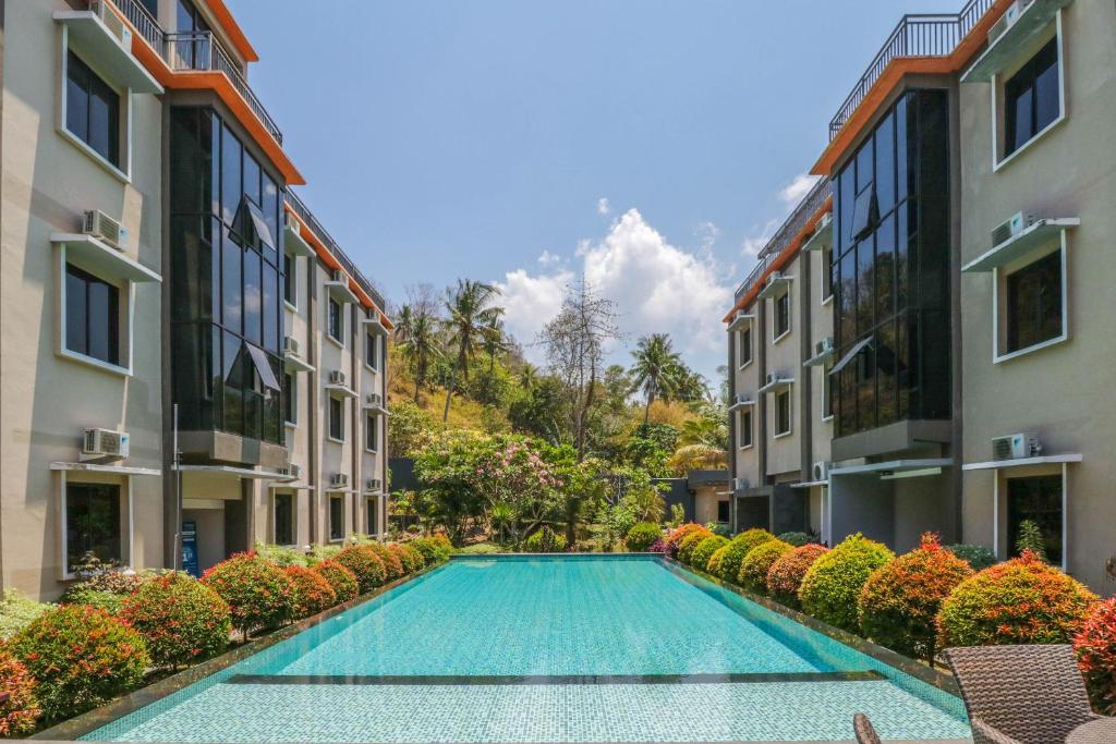 a swimming pool in a courtyard between two buildings at Grand Senggigi Hotel in Senggigi