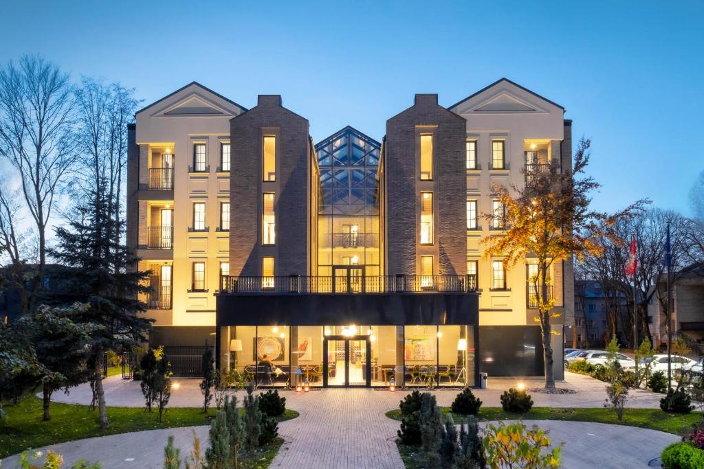 a large building with a courtyard in front of it at Amsterdam Plaza Hotel & SPA in Palanga