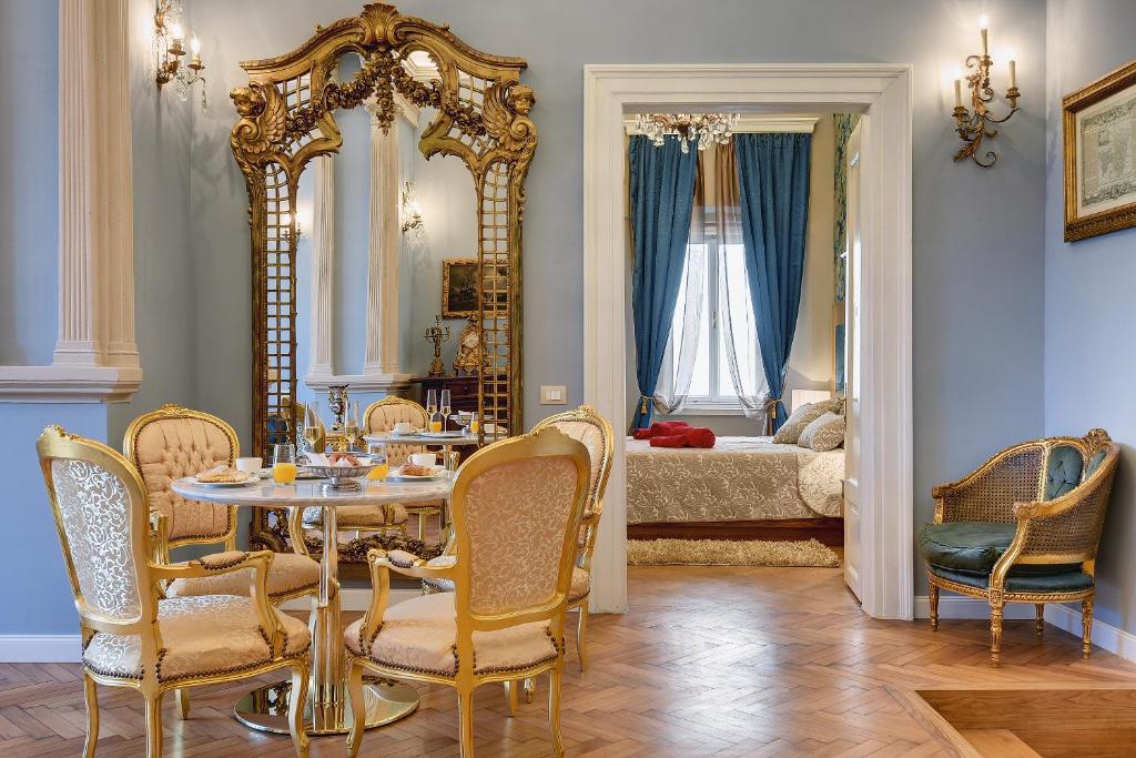 a dining room with a table and chairs and a bedroom at Demartini Palace in Pula