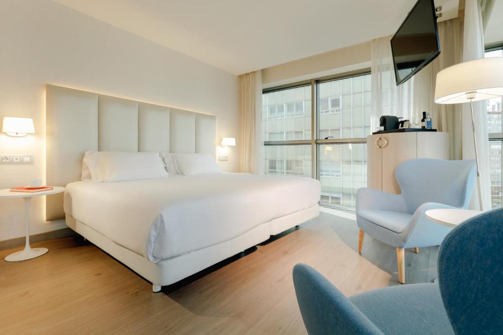 
a hotel room with a bed and a chair at Hesperia A Coruña Centro in A Coruña
