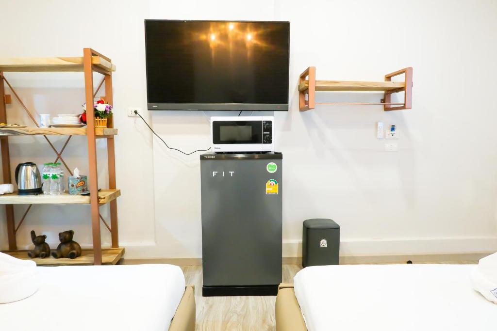 sala de estar con TV y nevera en Home de Bear, en Chiang Mai