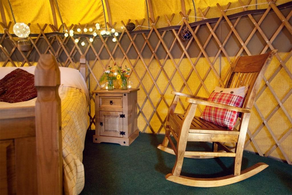 a room with a bed and a chair in a yurt at Portsalon Luxury Camping in Portsalon