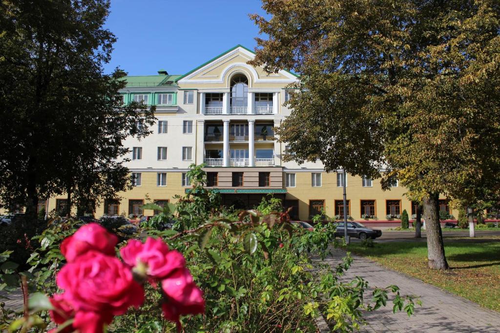 een groot gebouw met een roze bloem ervoor bij Volkhov in Veliki Novgorod