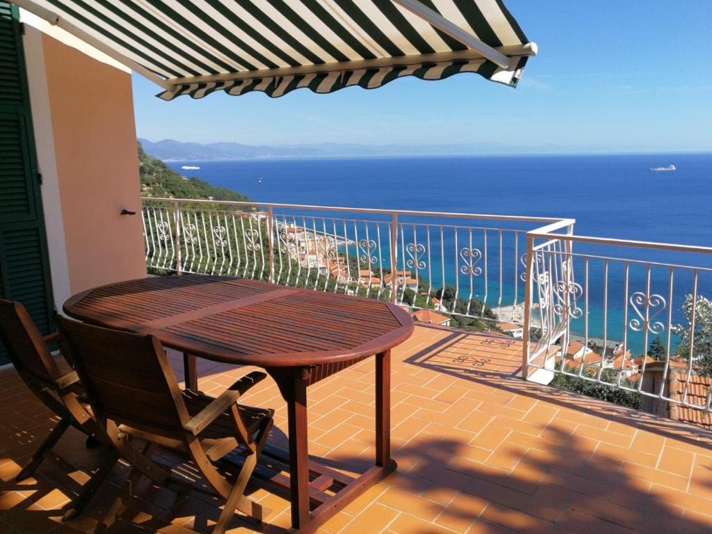 balcón con mesa y vistas al océano en Villa Giò - Terrazza nel Blu, en Bergeggi