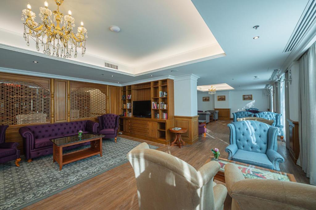 Another angle of the ornate lounge shows purple and blue seating beside tall windows.