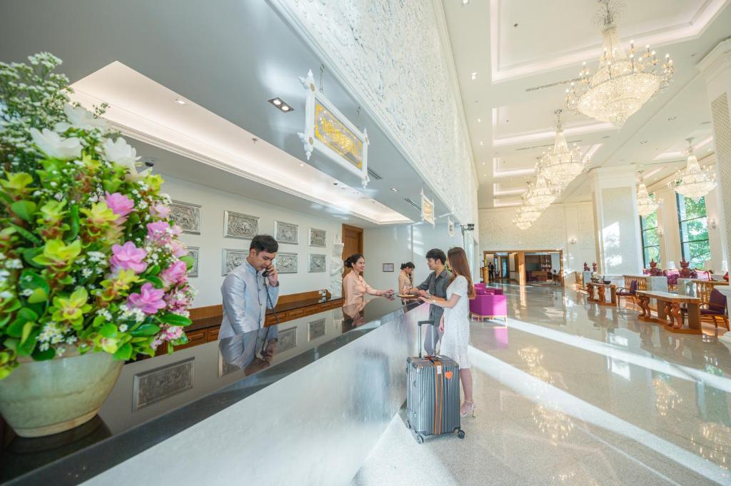 Guests check in at a long marble-fronted reception desk in the chandelier-lit lobby.