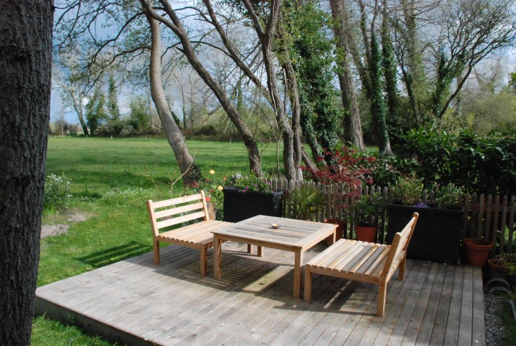 a wooden table and two chairs on a wooden deck at Ty Polder in Île-Tudy