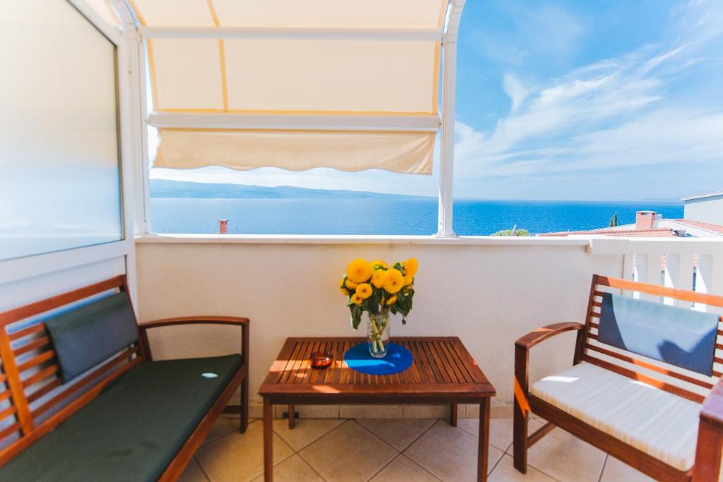 Pokój ze stołem, 2 krzesłami i oknem w obiekcie Apartmani Villa Marija w Omišu