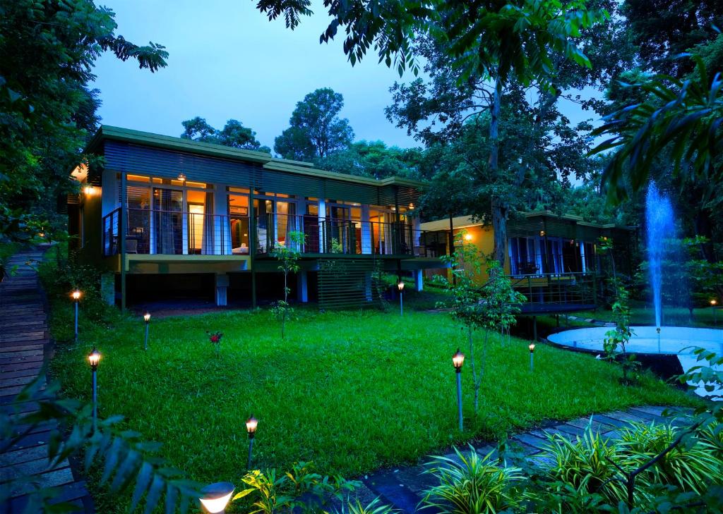 a house with lights in front of a yard at Kuruva Island Resort And Spa - By KABINI BREEZE, Wayanad in Mananthavady