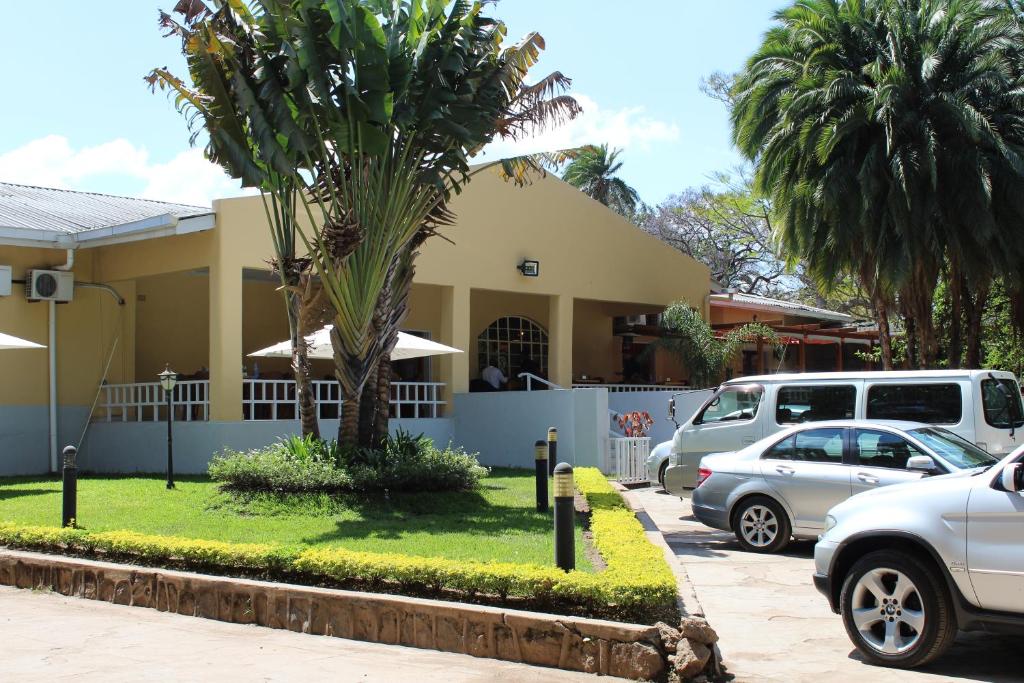 un bâtiment avec des voitures garées dans un parking dans l'établissement Casa Mia Lodge & Restaurant, à Blantyre