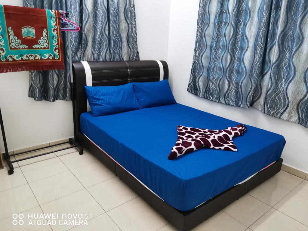 a bed in a room with a blue bed at Zara Homestay in Marang
