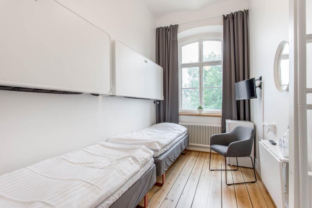 um quarto de hotel com uma cama e uma cadeira em Kronohäktet em Karlskrona