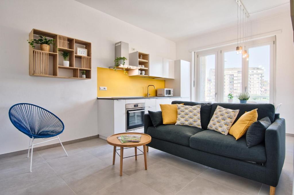 a living room with a blue couch and a table at Urban House Carducci - Apartments in Turin